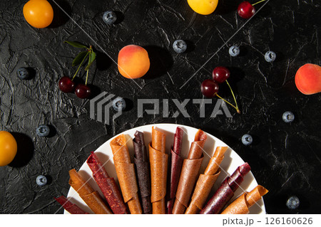 Fruit leather of apples and berries in rolls. Pastila. Background for text and articles on healthy eating. Raw food, vegan sweetness, dessert without sugar and flour. Fruit leather of apples and berries in rolls. Pastila. Background for text and articles on healthy eating. Raw food, vegan sweetness, dessert without sugar and flour. 126160626