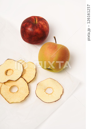 Frips. Slices. Dried apples on parchment paper. On a white background, place for text. Frips. Slices. Dried apples on parchment paper. On a white background, place for text. 126161257