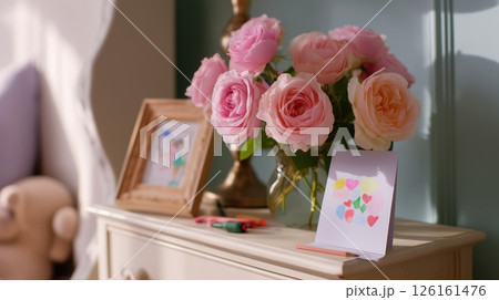 Beautiful bouquet of pink roses on a wooden table with colorful art in a cozy indoor setting 126161476