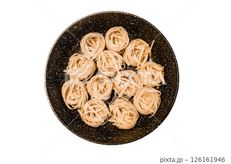 nests raw tagliatelle in pan top view isolated on white background with clipping path nests raw tagliatelle in pan top view isolated on white background with clipping path 126161946
