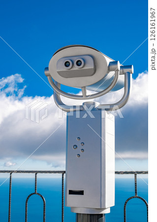 coin operated binocular on blue sky background coin operated binocular on blue sky background 126161967