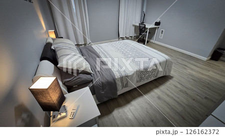 Modern bedroom interior featuring minimalist neutral decor, clean lines, wooden flooring, and soft bedding. The room exudes a cozy, inviting atmosphere for relaxation and comfort Modern bedroom interior featuring minimalist neutral decor, clean lines, wooden flooring, and soft bedding. The room exudes a cozy, inviting atmosphere for relaxation and comfort 126162372