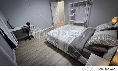 Modern bedroom interior featuring minimalist neutral decor, clean lines, wooden flooring, and soft bedding. The room exudes a cozy, inviting atmosphere for relaxation and comfort 126162382