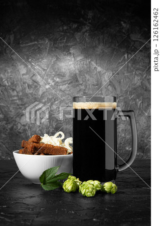 Dark beer with a snack on the table. Crackers with squid. Hop. Dark beer with a snack on the table. Crackers with squid. Hop. 126162462