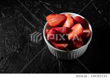 Delicious strawberries in a saucer on a black background. Delicious strawberries in a saucer on a black background. 126163132