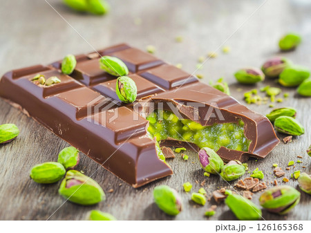 Dubai chocolate bar broken with pistachio filling on wooden table.AI Generative. 126165368