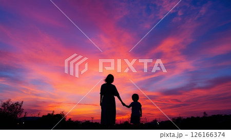 Silhouetted figures enjoying a colorful sunset while holding hands in a serene landscape Silhouetted figures enjoying a colorful sunset while holding hands in a serene landscape 126166374