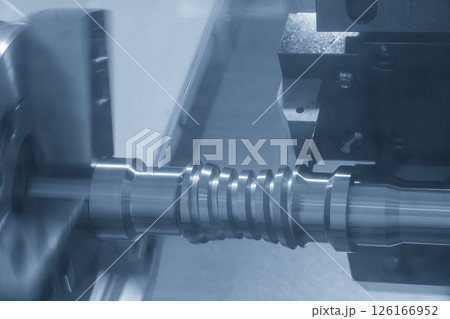 The CNC lathe machine groove cutting the metal ball screw shaft parts in the light blue scene. The CNC lathe machine groove cutting the metal ball screw shaft parts in the light blue scene. 126166952