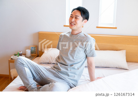 ベッドに座ってリラックスする日本人男性 126167314