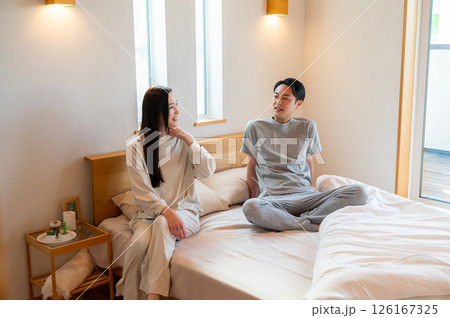 ベッドで座ってリラックスする日本人男女 126167325