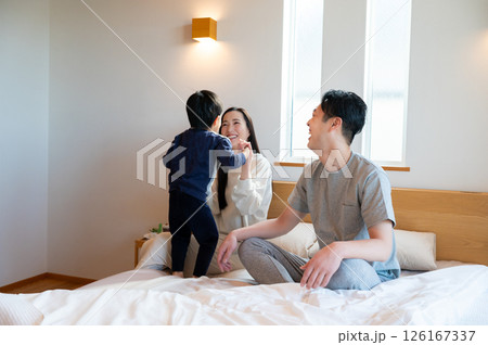 ベッドの上で子どもと遊ぶ日本人夫婦 ベッドの上で子どもと遊ぶ日本人夫婦 126167337