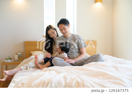 カップルが自宅で笑顔を交わしながらリラックスしたひとときを過ごすシーン カップルが自宅で笑顔を交わしながらリラックスしたひとときを過ごすシーン 126167375
