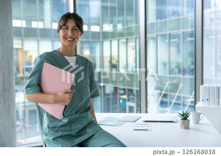 Smiling cute young female doctor looking positive and contented 126168038