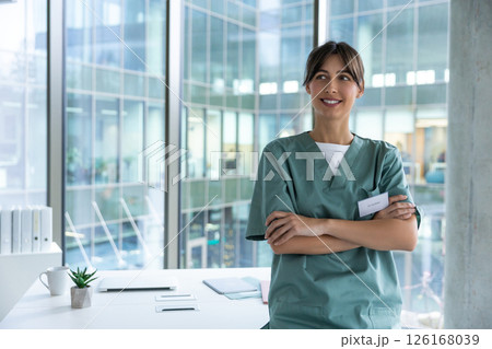 Smiling cute young female doctor looking positive and contented Smiling cute young female doctor looking positive and contented 126168039