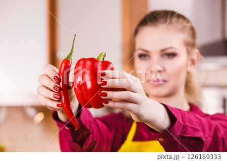 Woman holding bell pepper and chilli 126169333