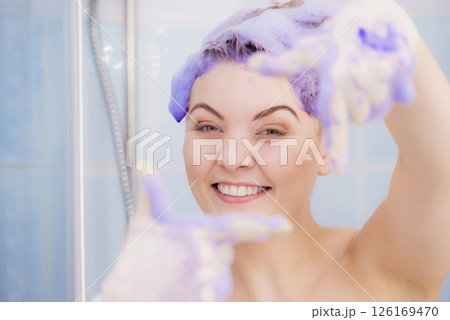 Woman applying toner shampoo on her hair Woman applying toner shampoo on her hair 126169470