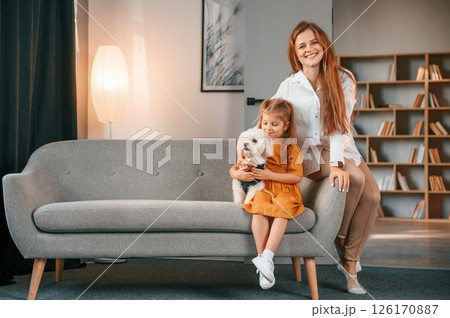 Mother with daughter is at home with maltese dog Mother with daughter is at home with maltese dog 126170887