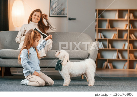 Mother with daughter is at home with maltese dog 126170900