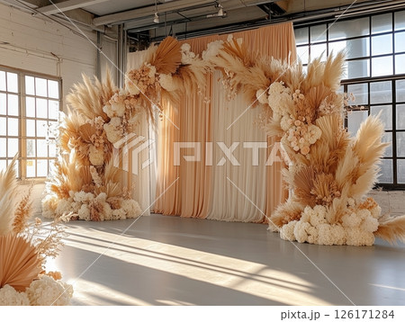 Floral wedding arch in boho-style indoor ceremony, cozy and artistic vibe. 126171284