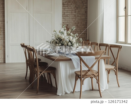 Indoor banquet with long tables, white flowers, candles, crystal glasses, elegant and intimate. Indoor banquet with long tables, white flowers, candles, crystal glasses, elegant and intimate. 126171342