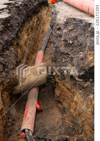 Repair of sewage heating systems or electricity. A trench has been dug in the ground. Repair of sewage heating systems or electricity. A trench has been dug in the ground. 126171393