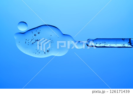 A dropper with a transparent serum texture on a blue background. 126171439