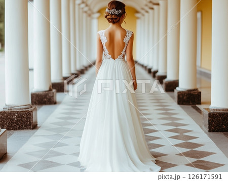 Bride standing back to camera in historic building with colonnade, elegant and classic scene. Bride standing back to camera in historic building with colonnade, elegant and classic scene. 126171591