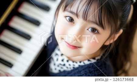 Happy girl learning piano. 126173668
