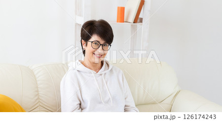 Happy woman relaxing on sofa at home banner with copy space. Positive lifestyle and mental wellness concept. 126174243