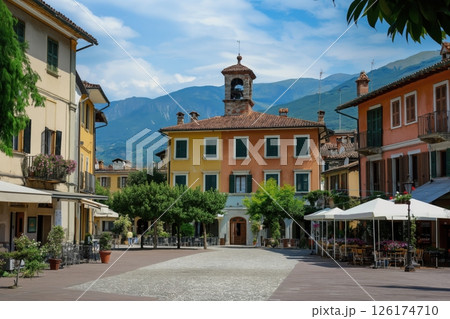 Picturesque italian town square with colorful buildings and a mountain view on a sunny summer day 126174710
