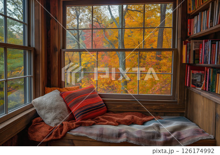 Cozy reading nook by a large window overlooking a vibrant autumn forest is bathed in warm sunlight Cozy reading nook by a large window overlooking a vibrant autumn forest is bathed in warm sunlight 126174992