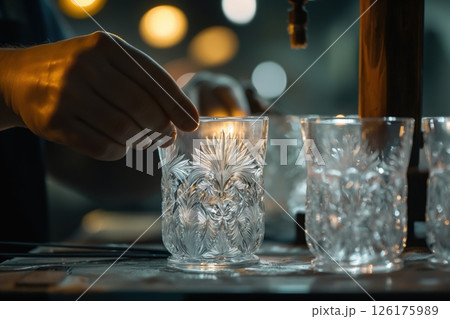 Glassblower is checking the quality of a crystal glass he just made in his workshop 126175989