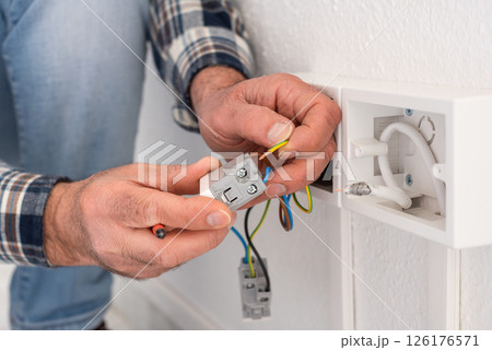 Electrician at work on a residential electrical system. Electricity. Electrician at work on a residential electrical system. Electricity. 126176571