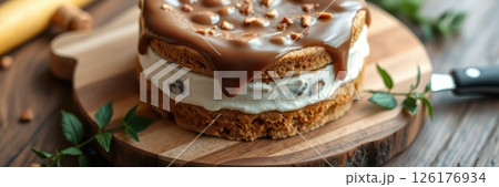 Delicious layered dessert with creamy filling and caramel topping on a wooden board in a cozy kitchen setting 126176934