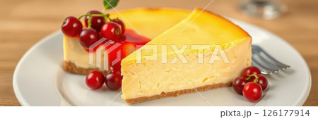 Creamy cheesecake topped with cherry sauce and fresh berries on a white plate Creamy cheesecake topped with cherry sauce and fresh berries on a white plate 126177914