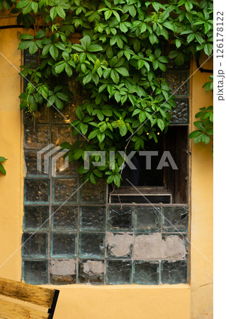 Interior Street cafe. Old window with flowers and French-style cafe table. Decor facade of coffee house. Interior Street cafe. Old window with flowers and French-style cafe table. Decor facade of coffee house. 126178122