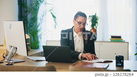 Business, woman and laptop with notebook at desk for schedule management, case preparation and planning. Attorney, employee and writing notes for lawsuit appointment and legal information at law firm 126178264