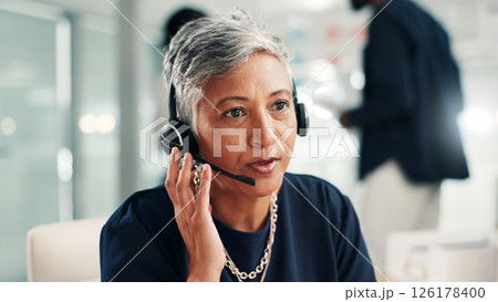 Mature woman, consultant and talking with headset at call center for online communication. Female person, agent or employee speaking with mic or technology for virtual assistance or help at office 126178400