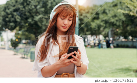 Park, walking and woman with headphones, phone or search online for streaming service on college campus. Outdoor, connection and university student girl with smartphone, music or podcast subscription Park, walking and woman with headphones, phone or search online for streaming service on college campus. Outdoor, connection and university student girl with smartphone, music or podcast subscription 126178615