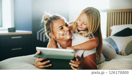 Happy mom, kid and relax with tablet on bed for online entertainment, show or cartoon at home. Mother, child or daughter lying with smile on technology for subscription, app or streaming in bedroom Happy mom, kid and relax with tablet on bed for online entertainment, show or cartoon at home. Mother, child or daughter lying with smile on technology for subscription, app or streaming in bedroom 126178800