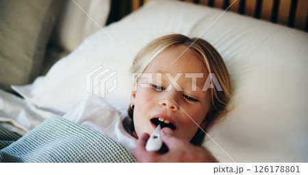 Bedroom, thermometer and sick with girl, parent and illness with symptoms, disease and care. Home, family and daughter in bed, checking fever and temperature with influenza, cold and monitor child 126178801