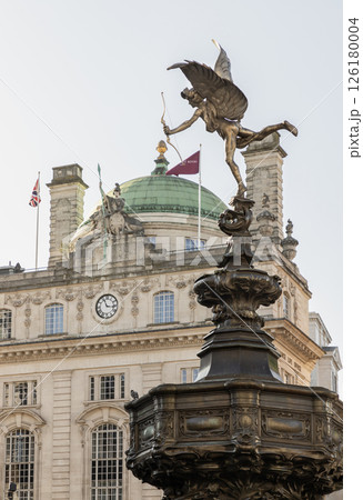The Statue of Eros is The Greek god anteros or the Greek God of love that sits atop of the Shaftesbury memorial fountain with Lillywhites and The Plaza Theatre building (Apollo cinema).  126180004