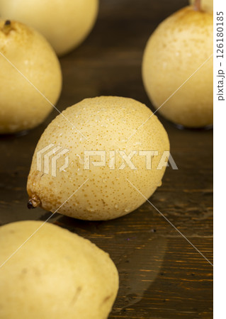wet sweet pears of white color with spots on the skin closeup, in drops of water, The pear is reflected in the table wet sweet pears of white color with spots on the skin closeup, in drops of water, The pear is reflected in the table 126180185