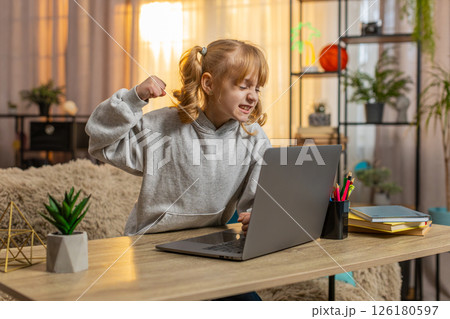 Young girl frustrated after losing game on laptop, expressing disappointment with upset reaction 126180597