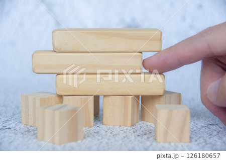 Hand pointing empty wooden blocks with customizable space for text. 126180657