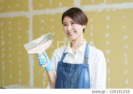石膏ボードにパテを塗るDIYする女性 石膏ボードにパテを塗るDIYする女性 126181238