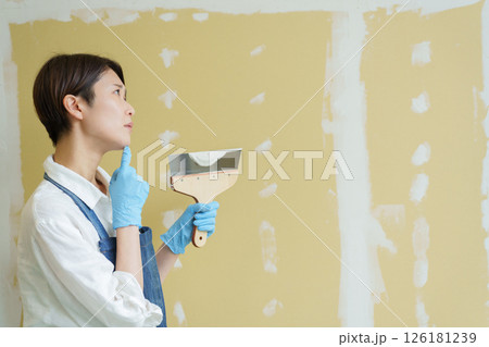 石膏ボードにパテを塗るDIYする女性 石膏ボードにパテを塗るDIYする女性 126181239