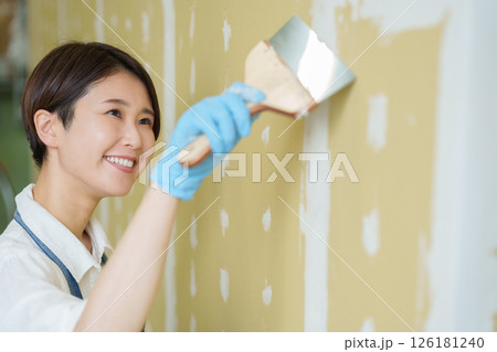 石膏ボードにパテを塗るDIYする女性 126181240