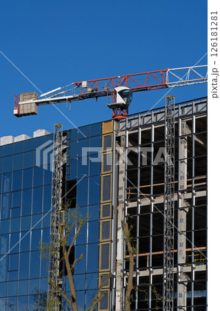 Building construction, glazing the facade of an office building. Object under construction. Installation of glass curtain wall. Glass wall of a monolithic building under construction. 126181281