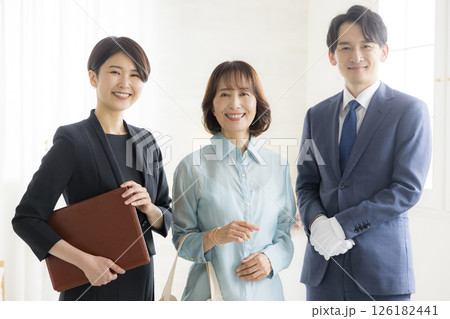 笑顔でファイルを持つビジネススーツ姿の男女 笑顔でファイルを持つビジネススーツ姿の男女 126182441